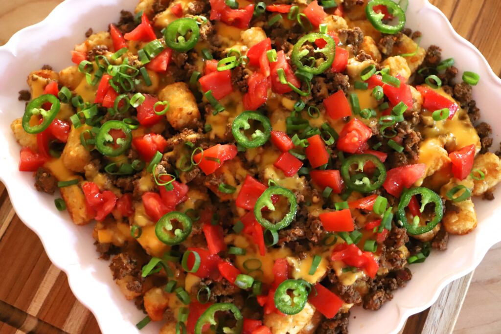 Assemble Tachos: top with diced tomatoes, sliced green onions, and jalapeño slices