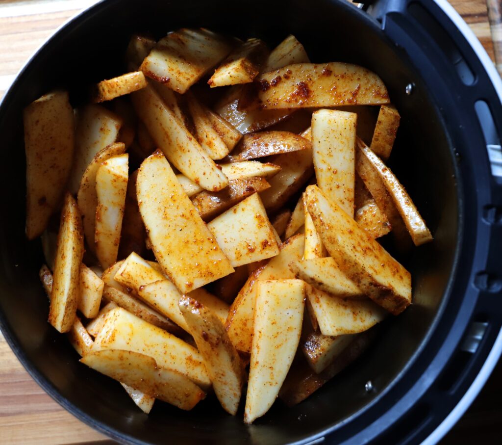 Place the seasoned potato wedges into the air fryer basket.