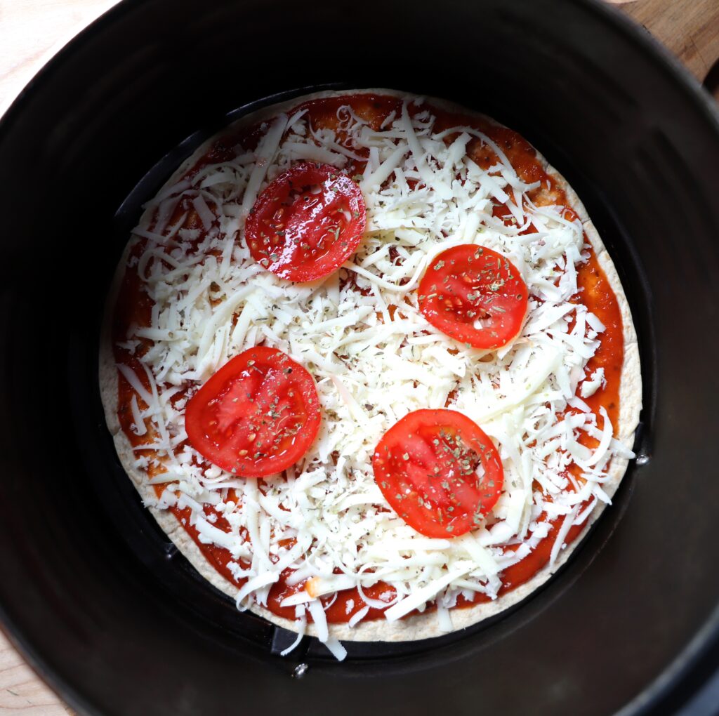 Place the tortilla pizza on the bottom of the air fryer basket.